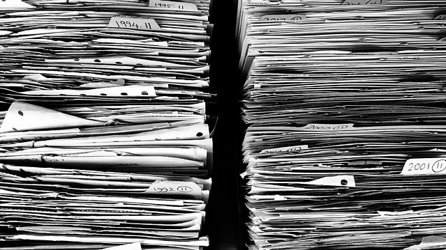 2 huge stacks of paper sitting side by side - negotiate your inbox